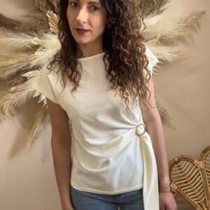 Détail t-shirt écru avec boucle dorée au niveau de la taille